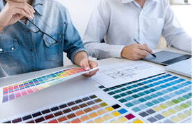 Two men in Drummondville look at color palettes. There is an architect's plan on the table.